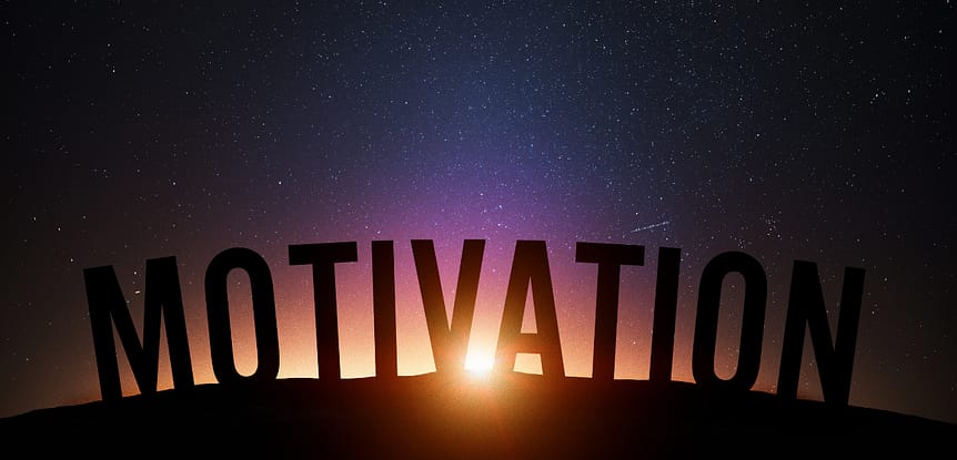 Expert tips on how to get motivated during the new year. The work motivation in block letters over the horizon of a sunset.