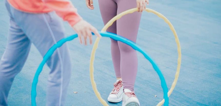 Cool Summer Fitness Workouts. Two women holding hula hoops.
