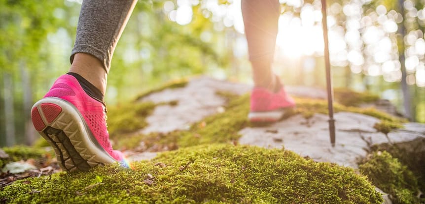Part 1 How to Get on Track with Your Fitness - for Life! Woman's feet with hot pink sneakers hiking over a moss covered forest floor.